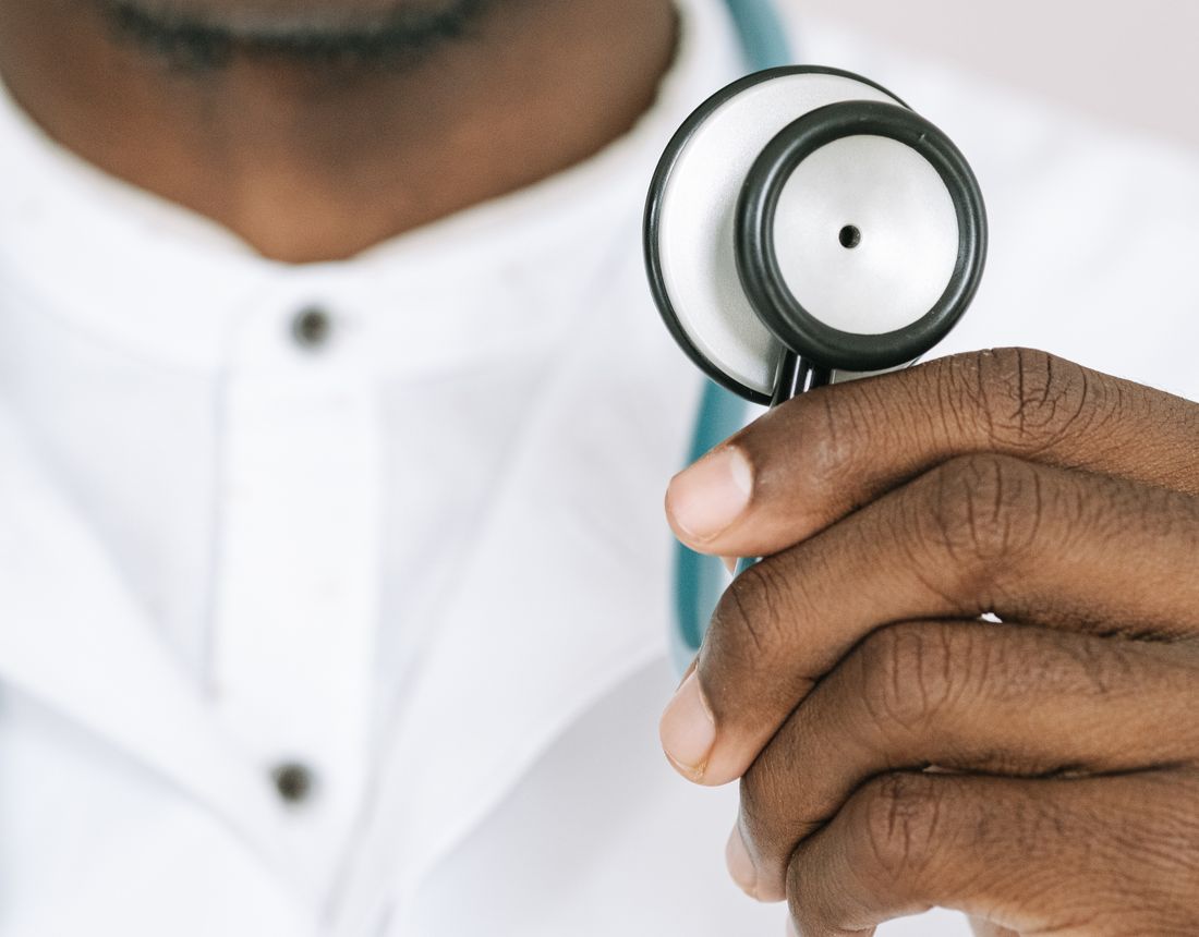 Clinician holding a stethoscope during a heart health check